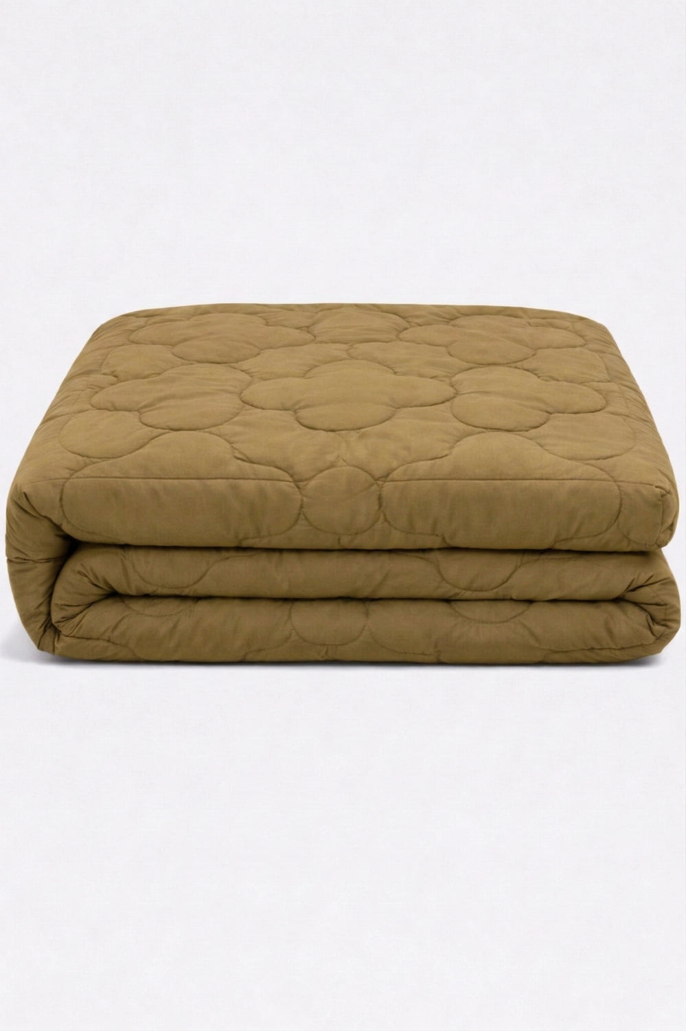 folded mustard beige comforter with clover quilted pattern stacked to highlight soft padded texture