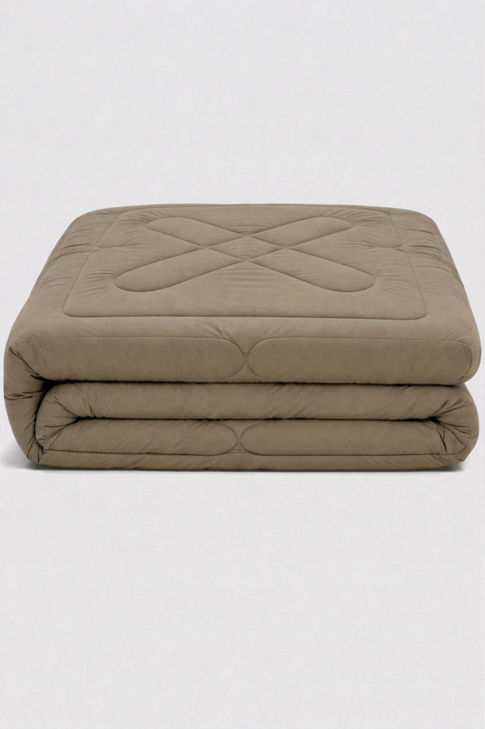 folded beige comforter with diamond quilted pattern neatly stacked to highlight soft padded texture