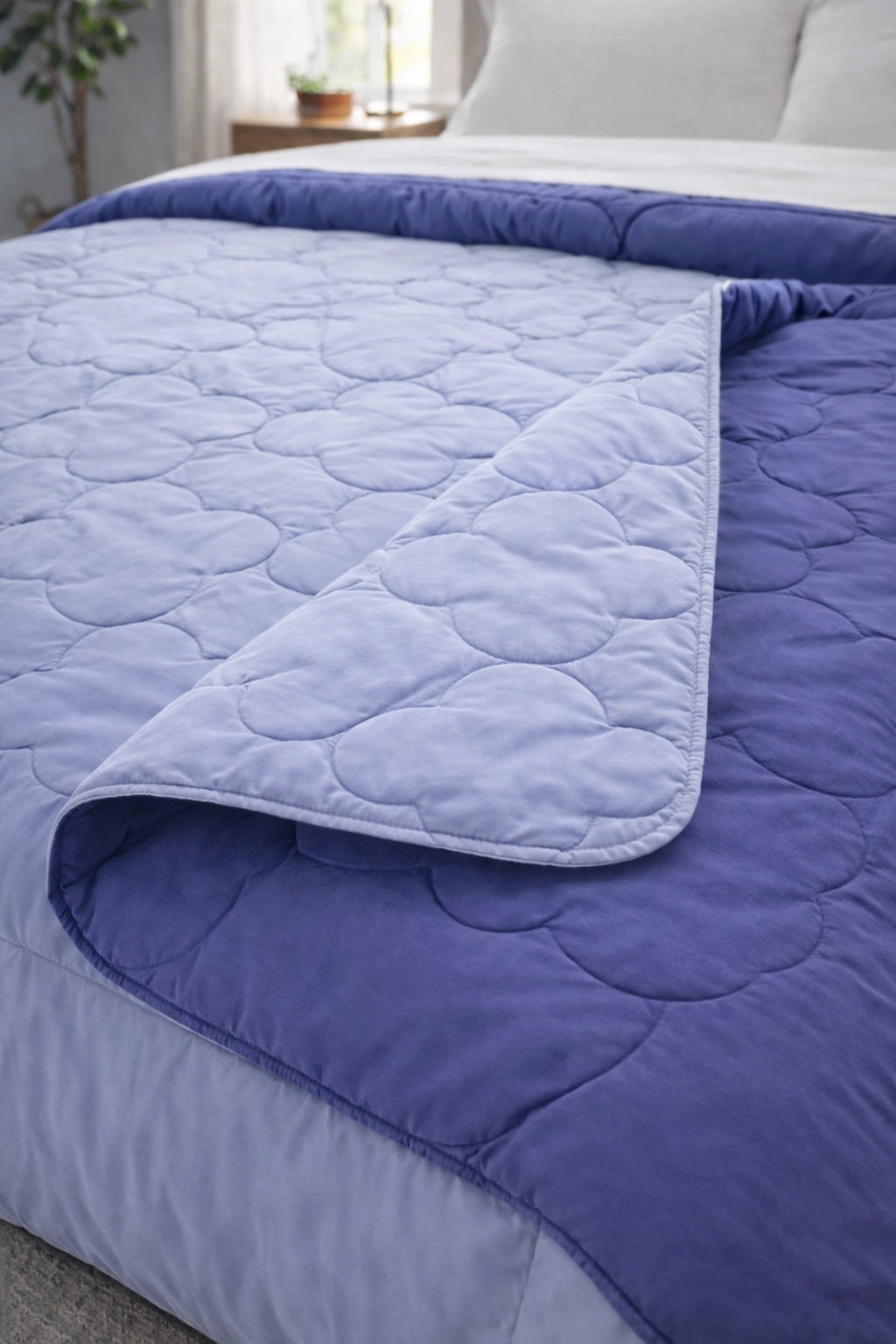 Close-up of folded Lilac and Lagoon microfiber comforter showing quilted stitching pattern