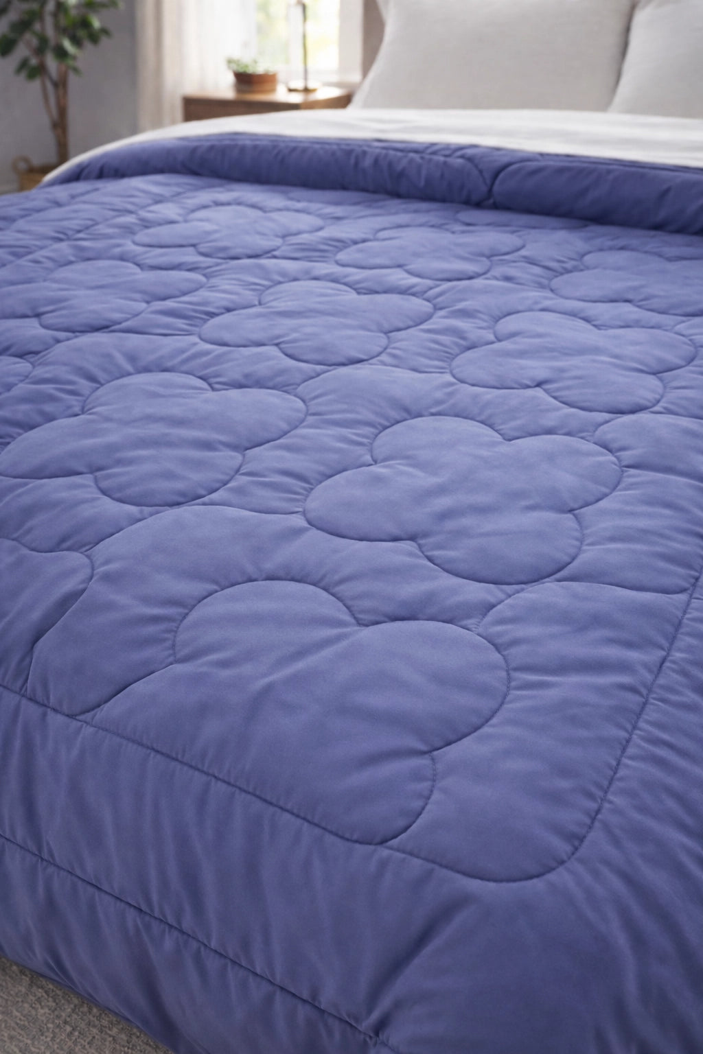 Detailed view of quilted clover stitching on Lilac and Lagoon reversible comforter fabric