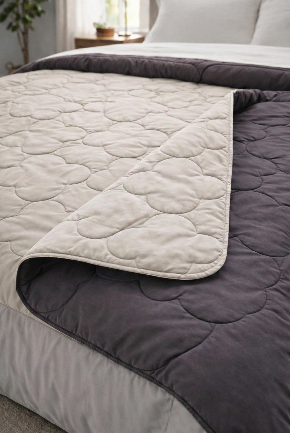 Folded corner of comforter revealing layered microfiber filling and stitched quilt pattern